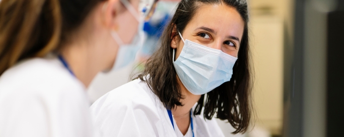 Doctor with mask on talking with another doctor